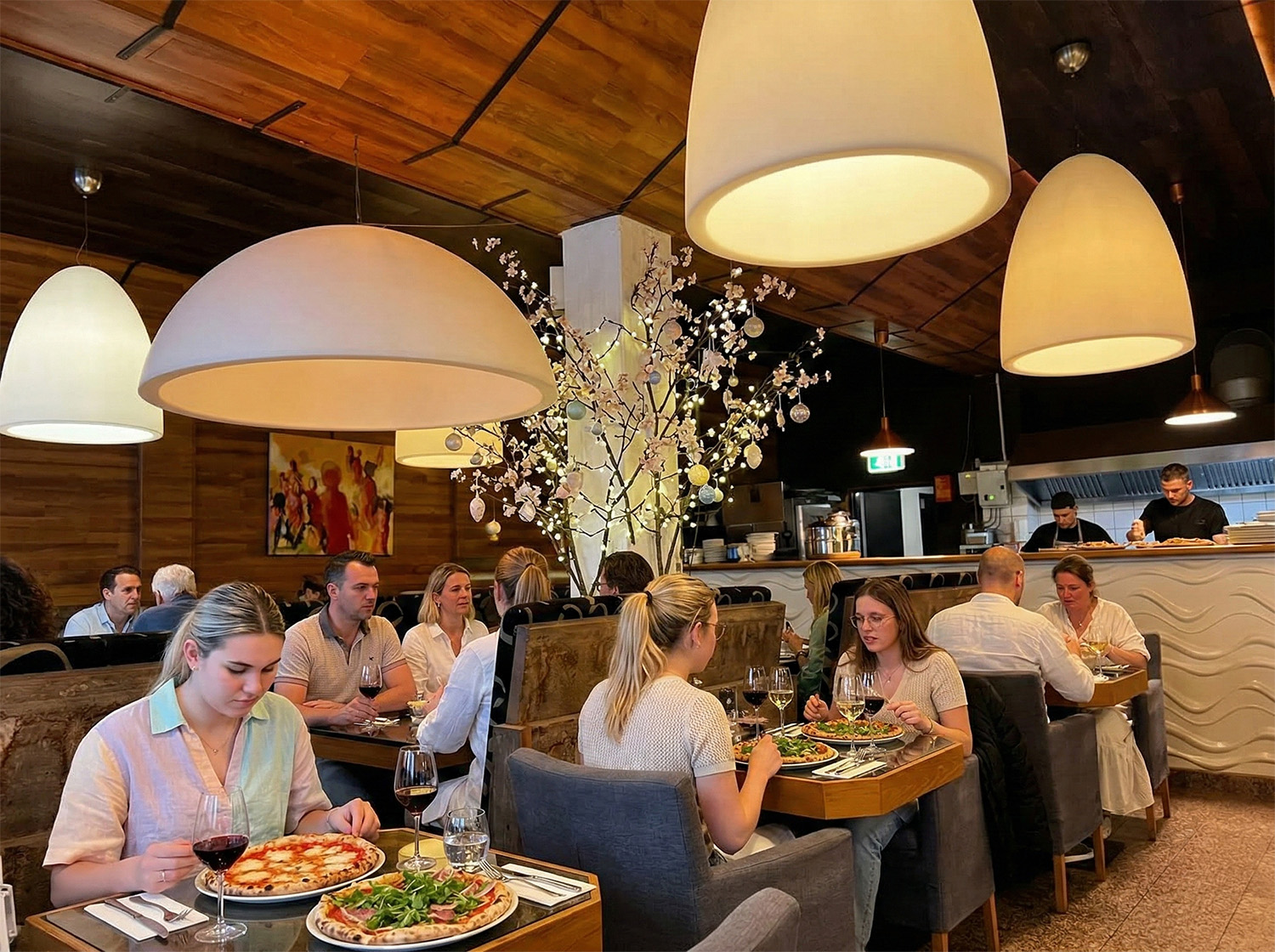 Gasten genieten van pizza en Italiaanse gerechten in het sfeervolle interieur van Restaurant Il Ponte in Son en Breugel